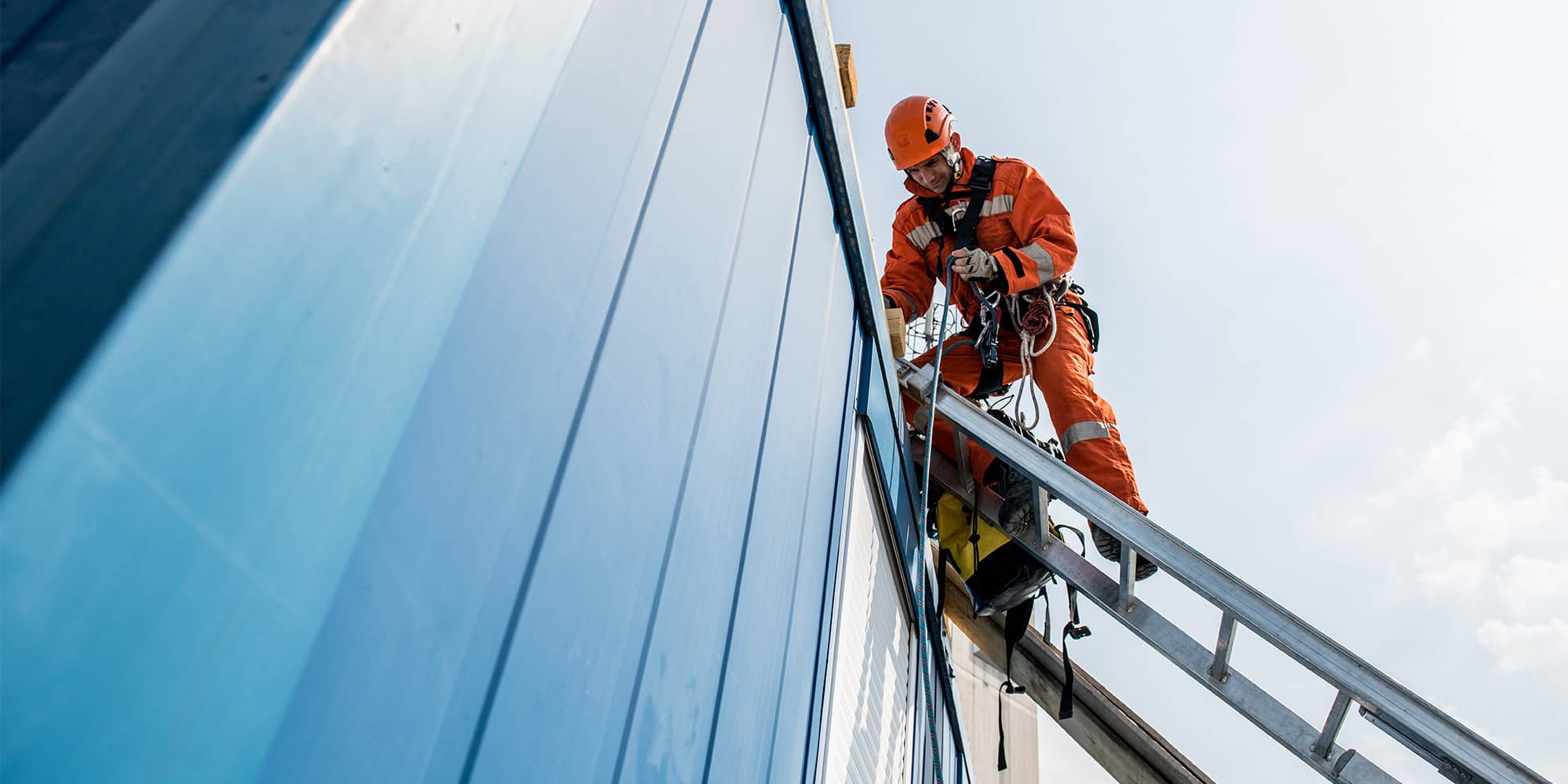 Man repairing exterior building on ladder