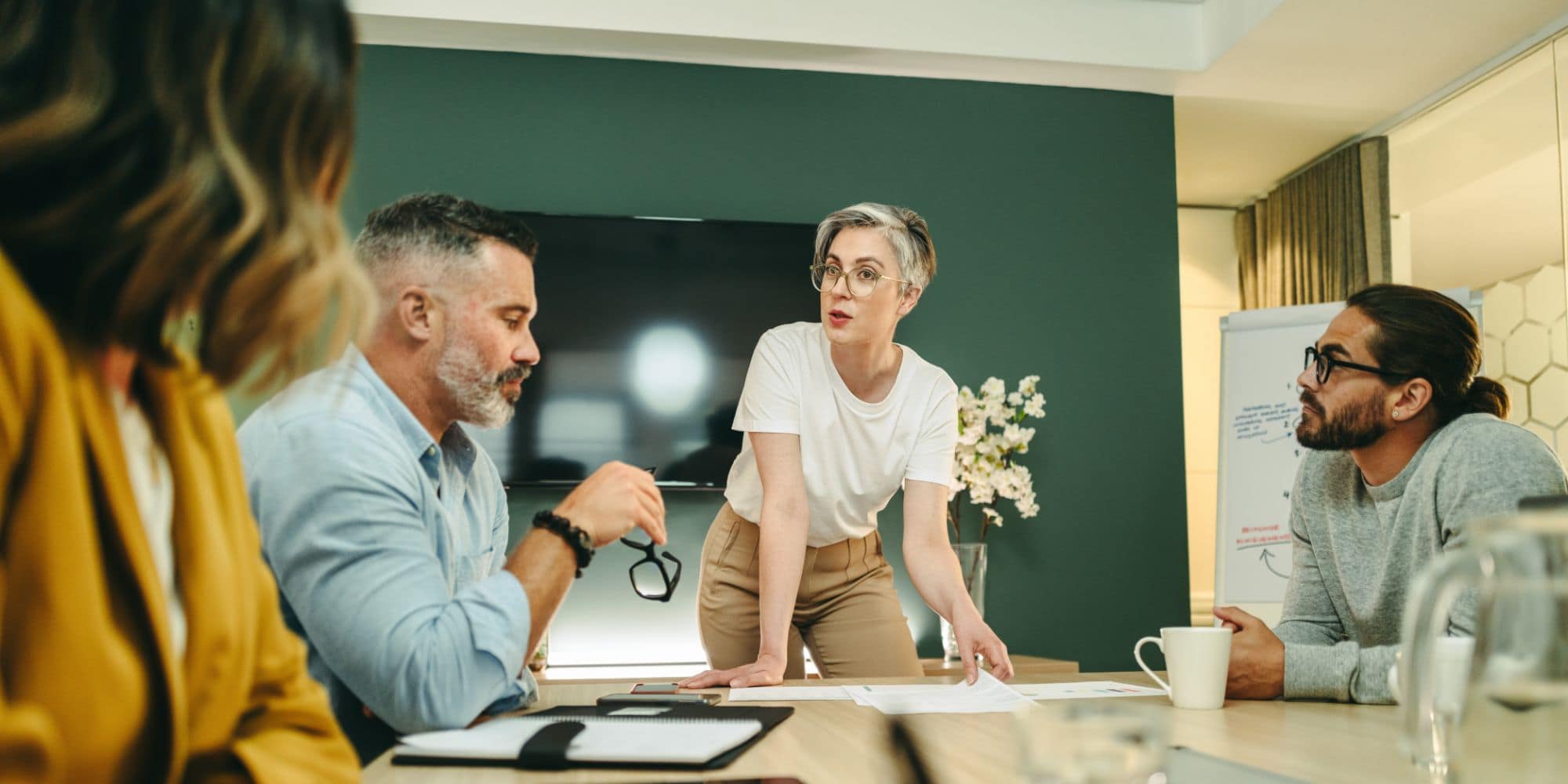 Mature businesswoman leading an important discussion in a boardroom. Group of creative businesspeople sharing ideas during a meeting in a modern workplace.