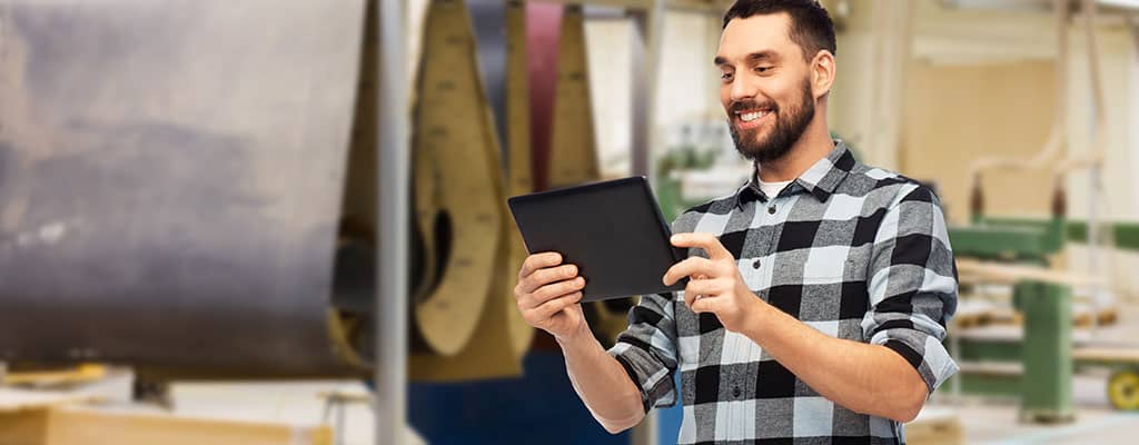 close-up man using tablet in workshop