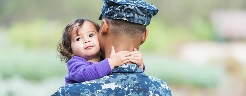 US military man holding baby girl
