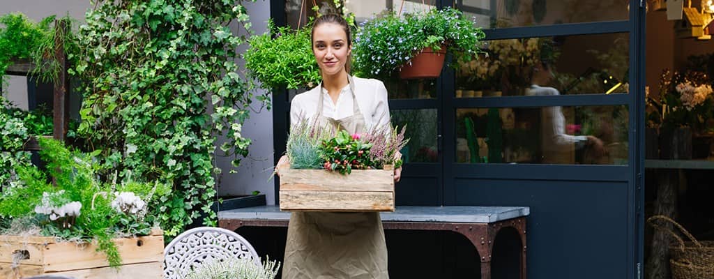 female florist holding a crate of flowers