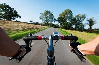 View of bicycle handle bars riding down open road