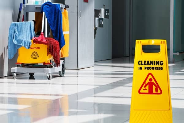 Cleaning in progress sign with janitor cart
