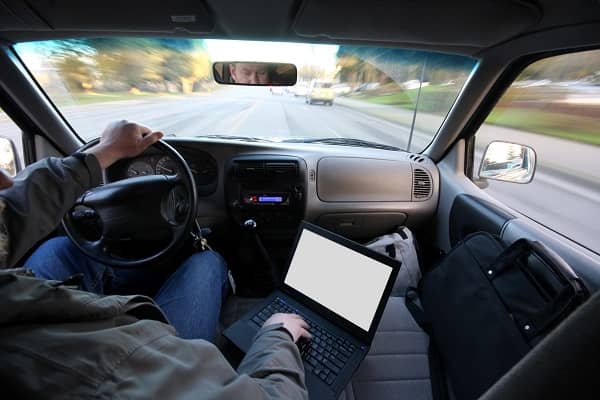 Distracted driver looking at computer