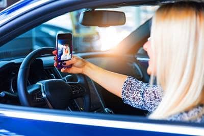 Woman in car taking selfie