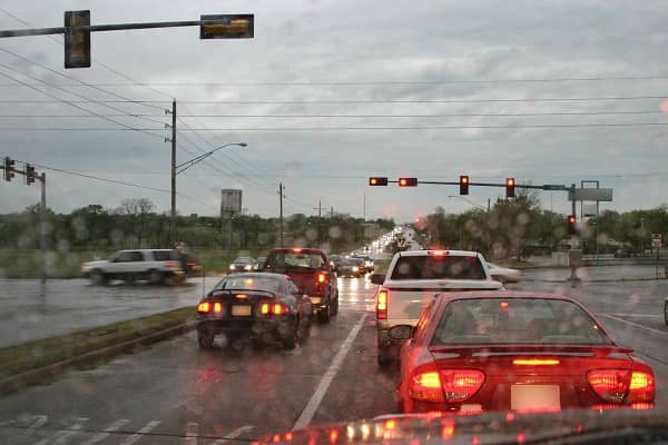Car brake lights at a traffic light in the rain